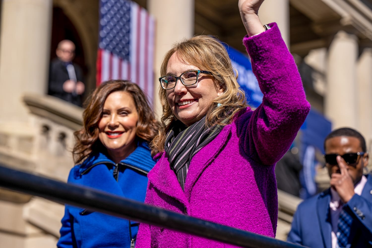 Gabby Giffords and Michigan Governor Gretchen Whitmer wave to the crowd at a rally outside the Michigan State Capitol.